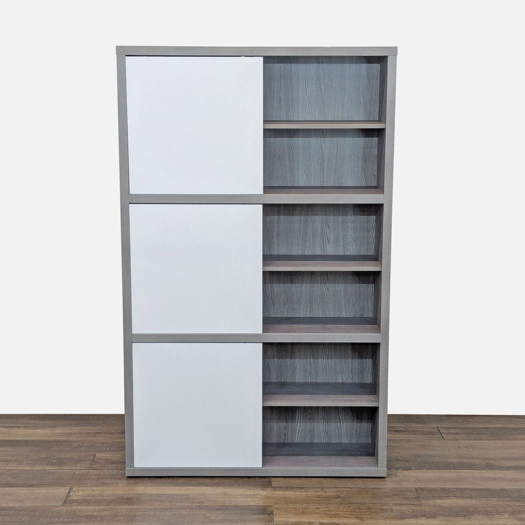 Eco-friendly bookshelf in gray faux-cement with three glossy white sliding doors, suitable for modern interiors.