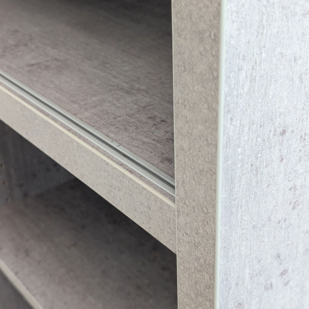 Close-up of the Sten Bookcase showing recycled faux-cement texture and smooth shelving detail by Scandinavian Designs.
