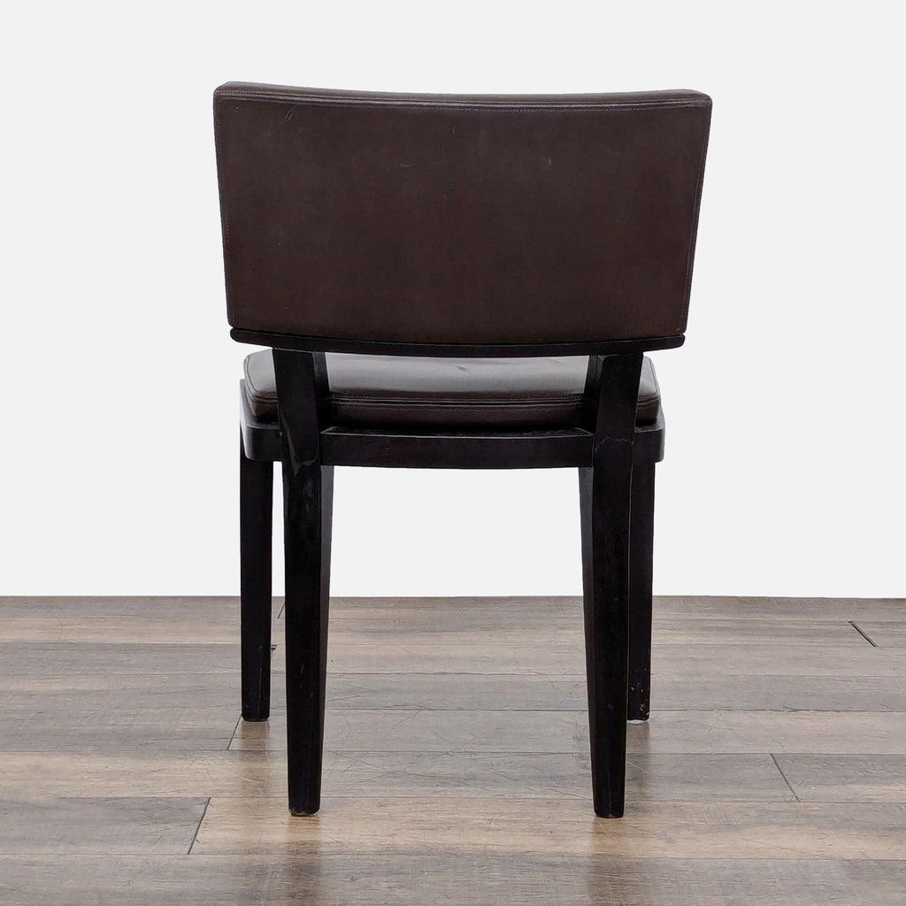 3. Rear view of a Harry dining chair by Holly Hunt/Christian Liaigre, with dark wood legs and brown leather back.