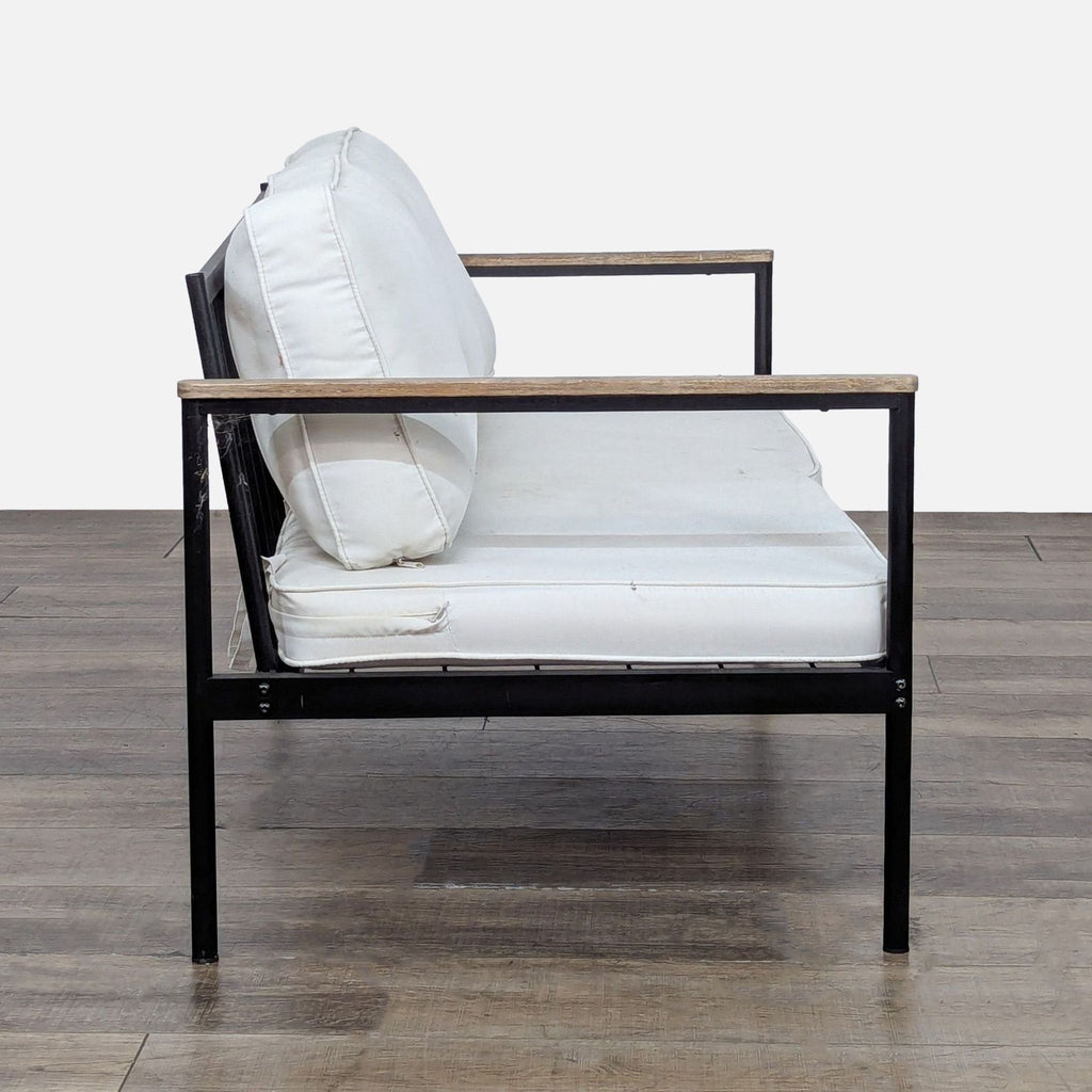 2. Side view of Reperch chair showing metal structure, wood armrests, and plush removable cushions.  