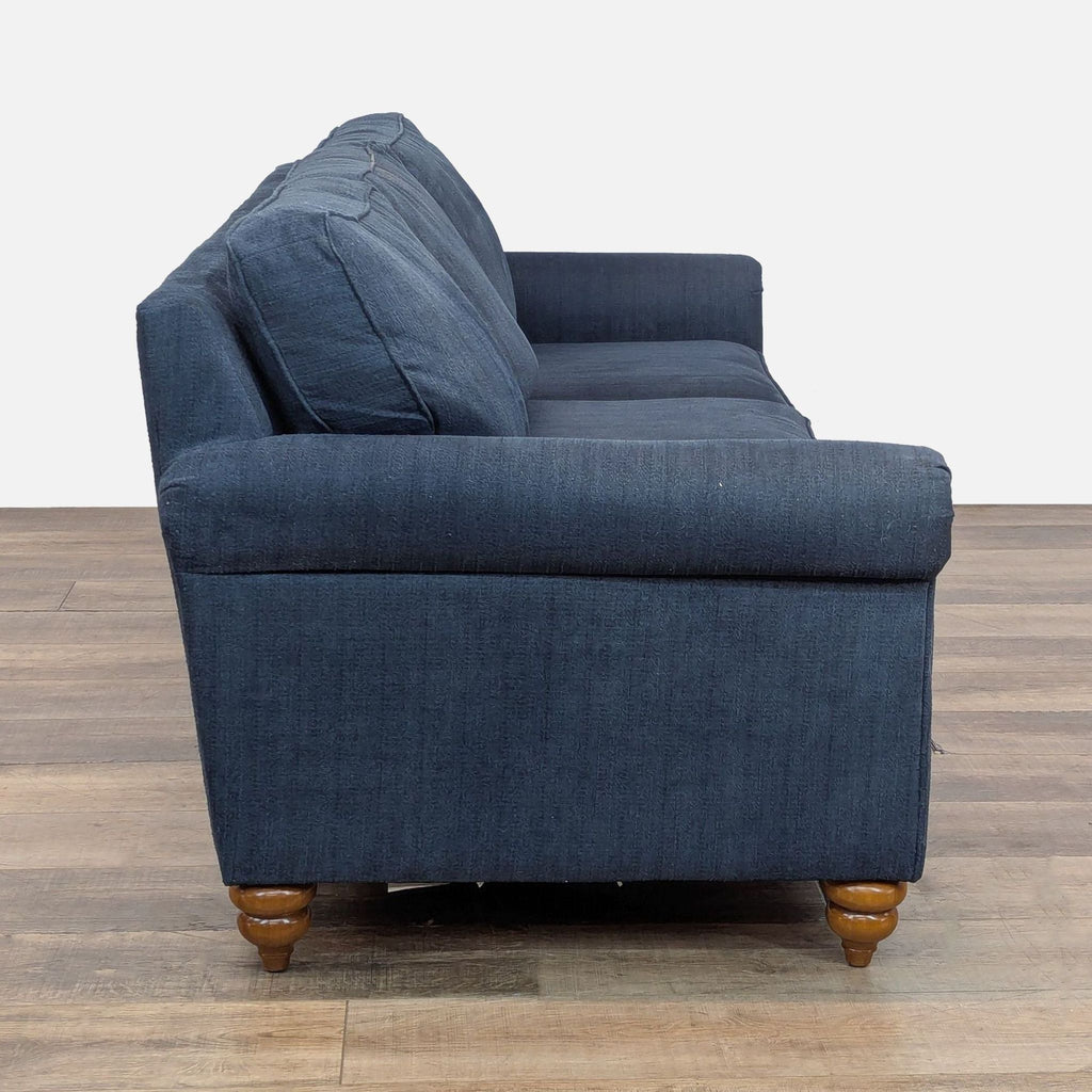 2. Side view of La-Z-Boy 3-seat sofa featuring blue upholstery and rolled arms with turned wooden feet.  
