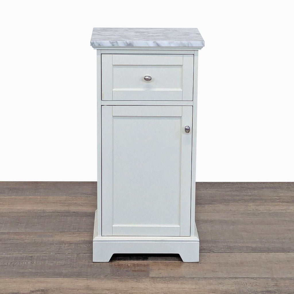 White Pottery Barn end table with a marble top, one drawer, and a cabinet door, seen from the front.