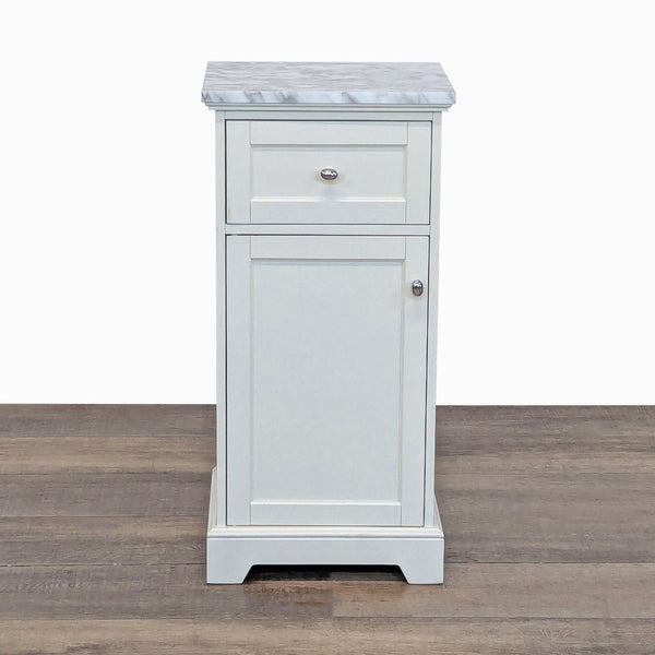 White Pottery Barn end table with a marble top, one drawer, and a cabinet door, seen from the front.
