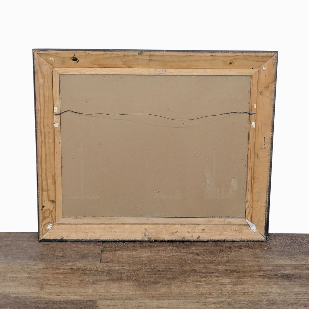 3. Back view of the framed Monet print, showing wooden frame, cardboard backing, and hanging wire.