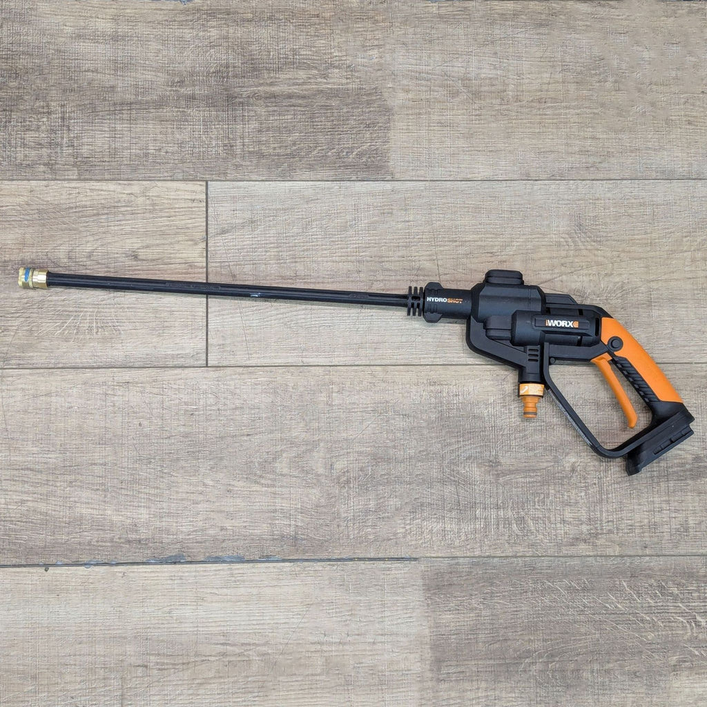 Worx WG620 cordless Hydroshot power cleaner with long nozzle, featuring an ergonomic black and orange handle.  