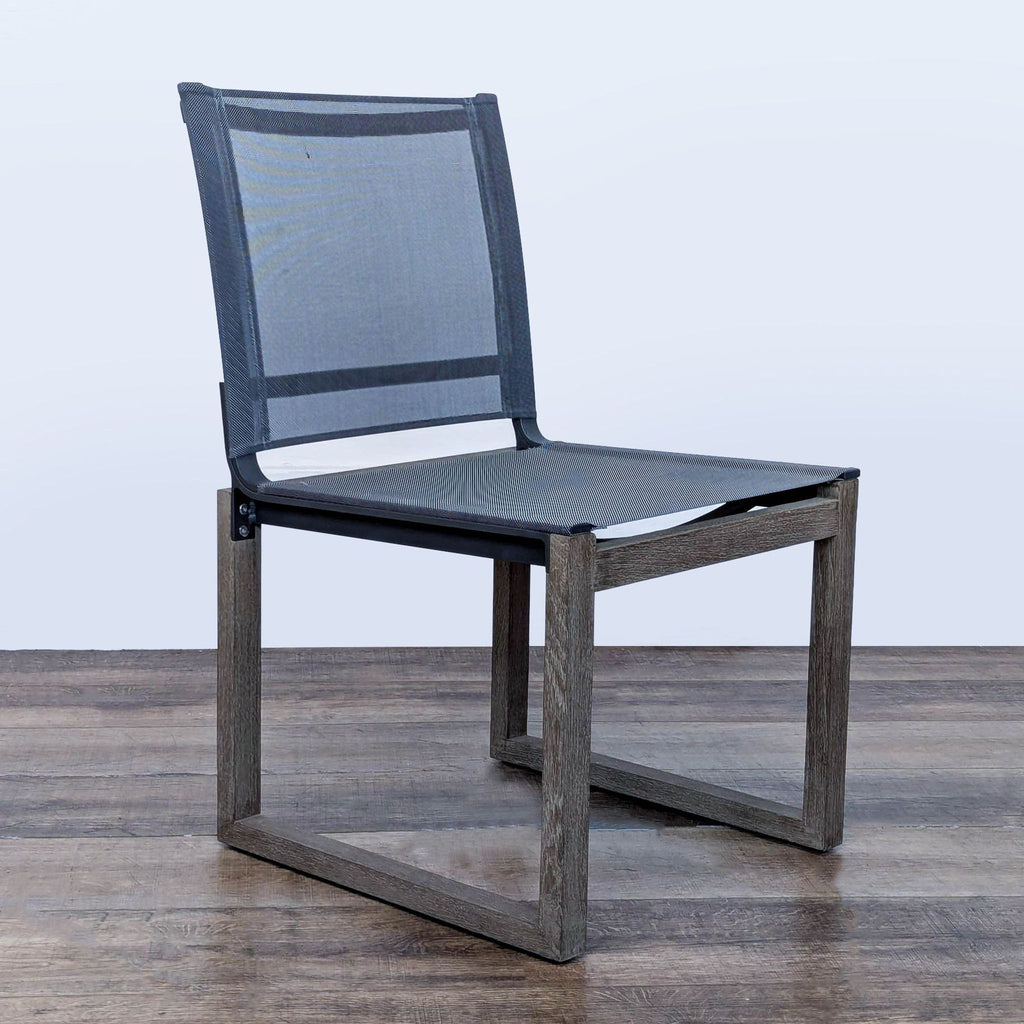 3. Angled view of the Aegean outdoor dining chair, crafted from weathered teak with a mesh seat and backrest.