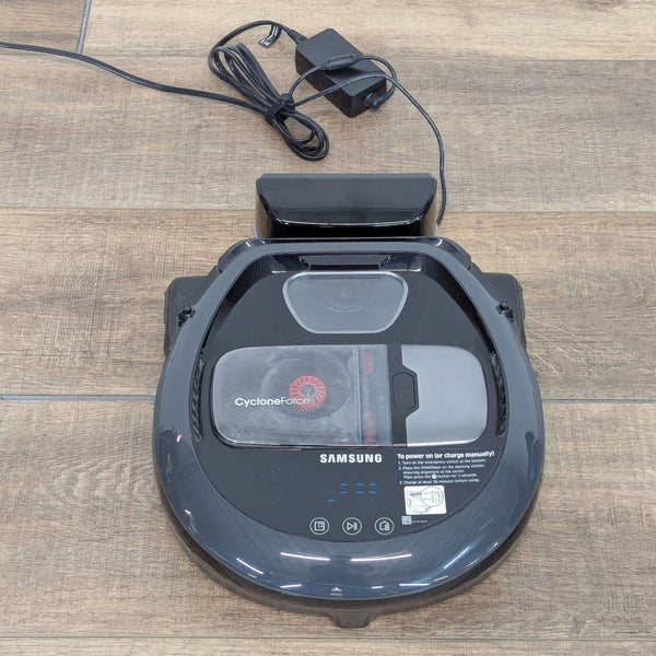 1. Samsung POWERbot SR1AM7040WG robotic vacuum in gray with charging dock, shown on a wooden floor from above.