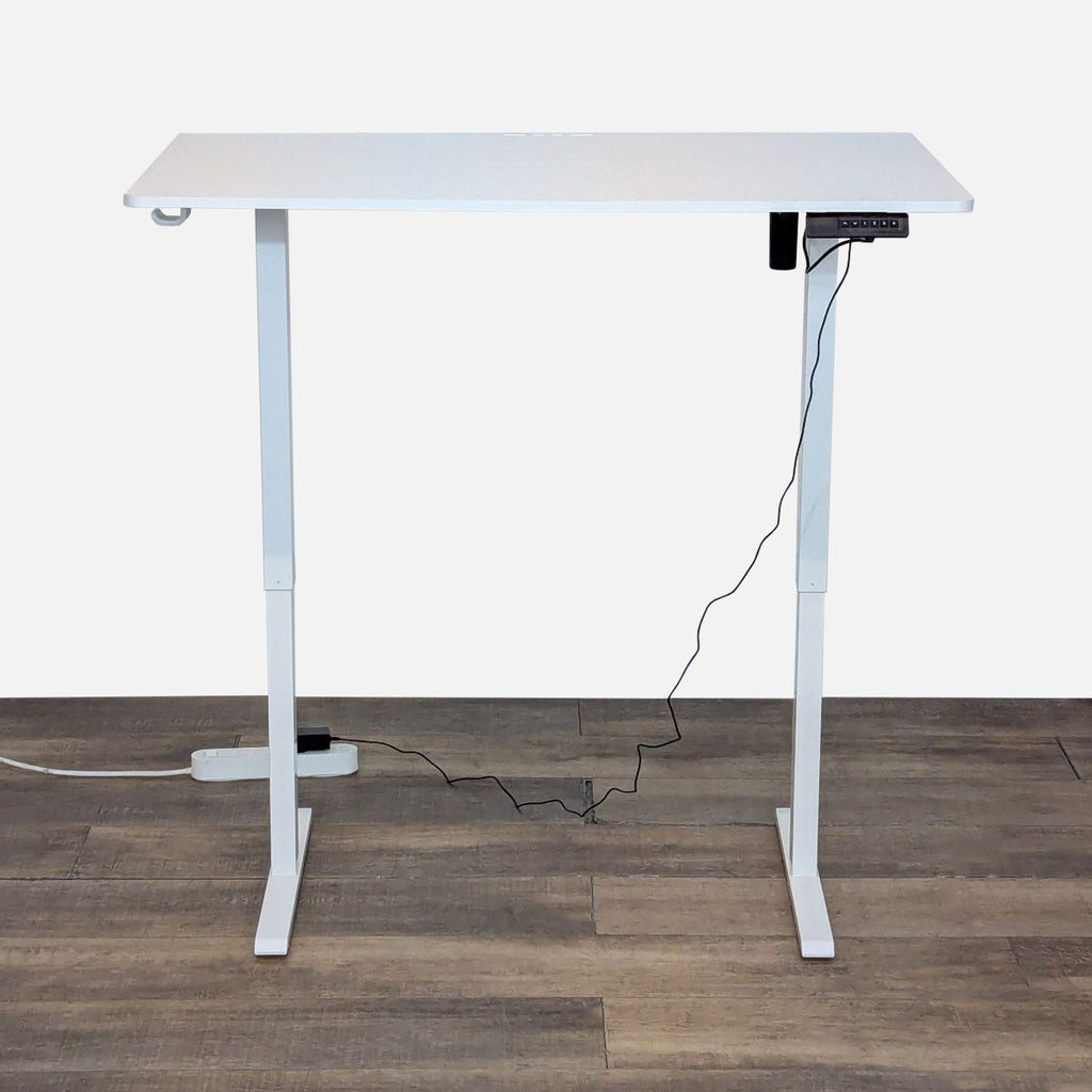 Standing desk from Bestqi Innovation raised to a higher position with programmable height controller and visible power cord.