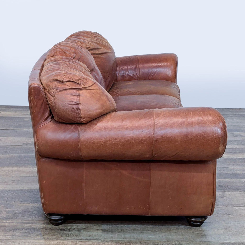 2. Side view of Reperch 3-seat leather sofa featuring rolled arm and cushioned back and seat.
