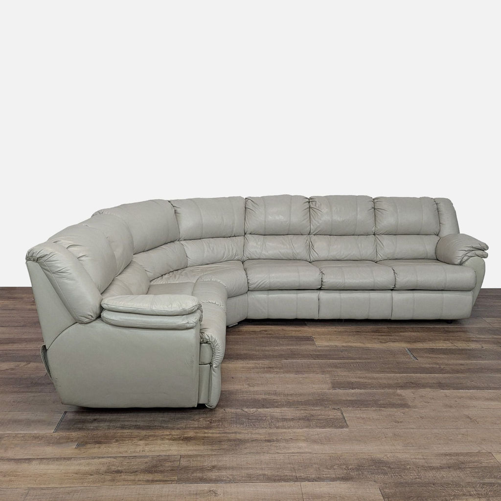 1. Ashley sectional sofa in light leather, featuring plush seating and a built-in recliner, shown on wood flooring.