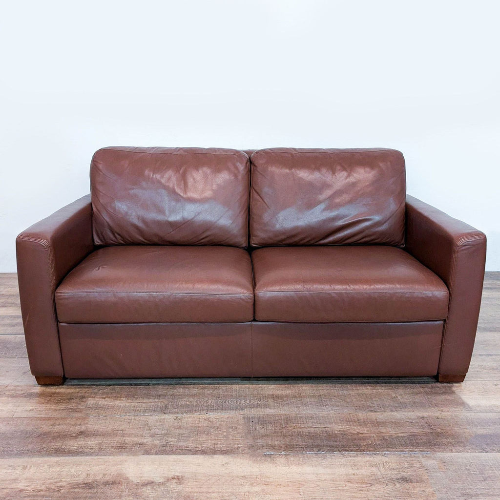 1. Brown leather sleeper sofa with track arms and wood block feet by American Leather, front view.
