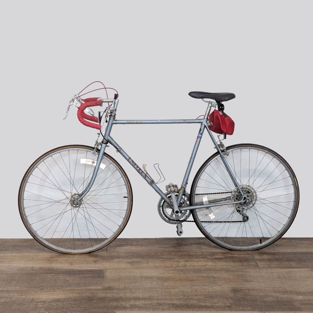 Side view of a classic Univega sports bicycle showcasing slim frame, red handlebar tape, and traditional gear setup.  