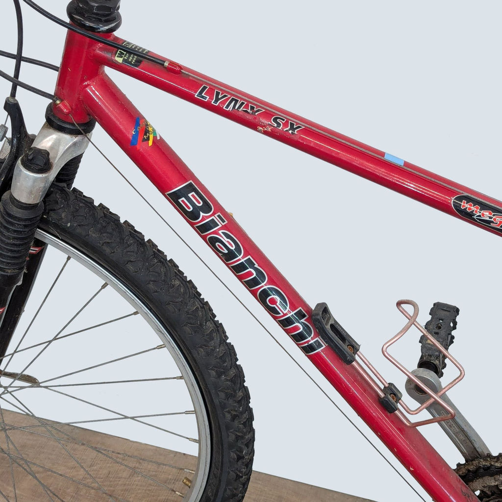 Close-up of a red Schwinn bike’s frame and front wheel, highlighting its quality components and sturdy construction.
