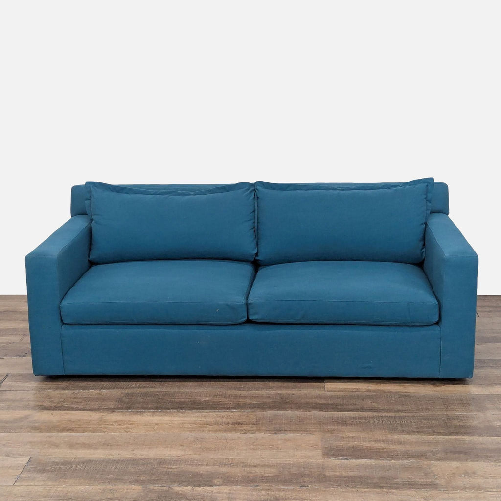 1. Blue Anthropologie sleeper sofa with t-shaped cushions and performance linen upholstery, shown from the front.