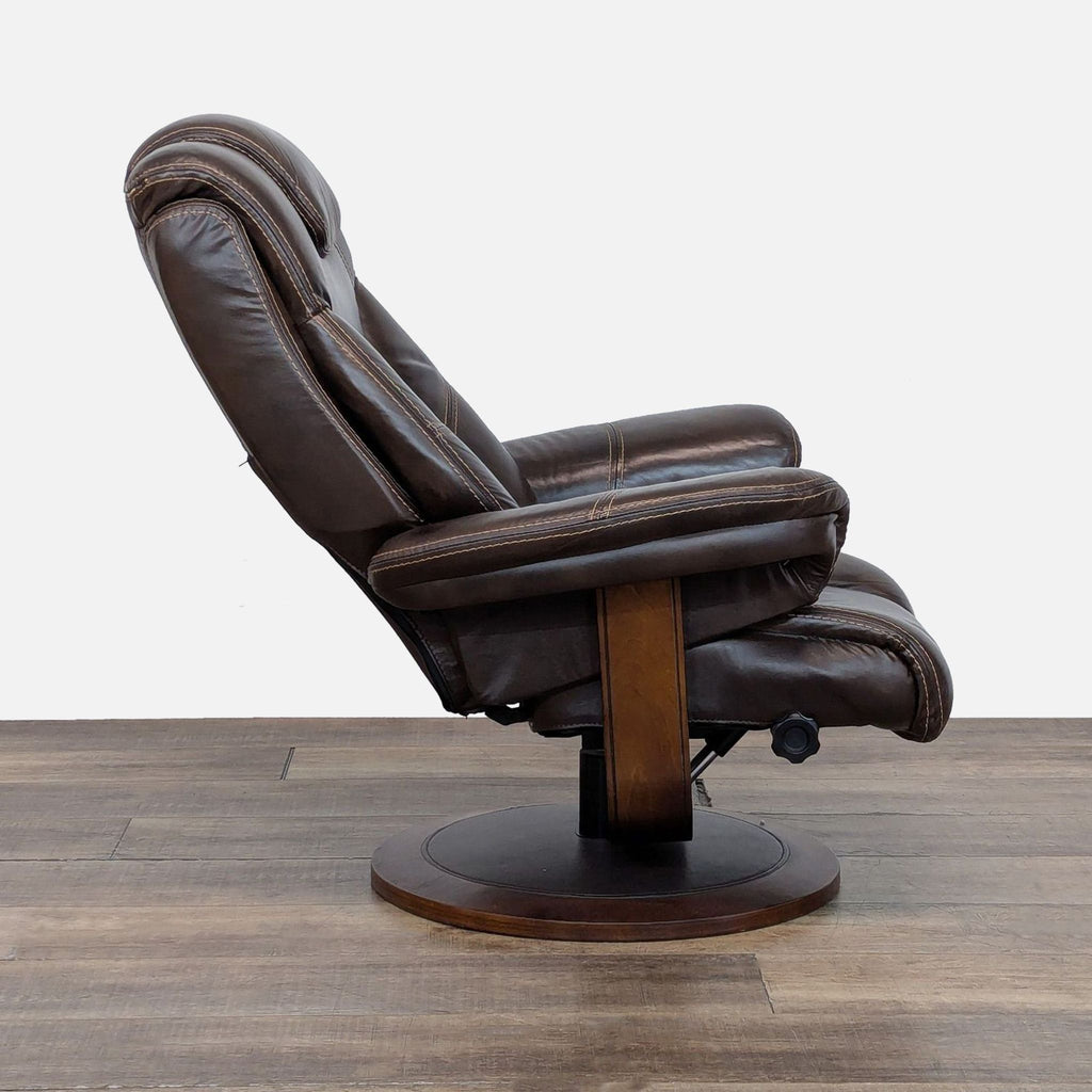 2. Side view of a Macy’s cushioned leather lounge chair on a circular walnut base; non-adjustable recliner.