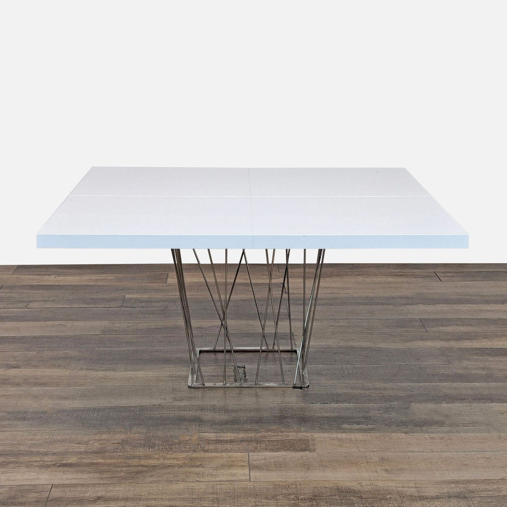 2. Modern white square dining table by Modloft featuring a sleek wiry stainless steel base.