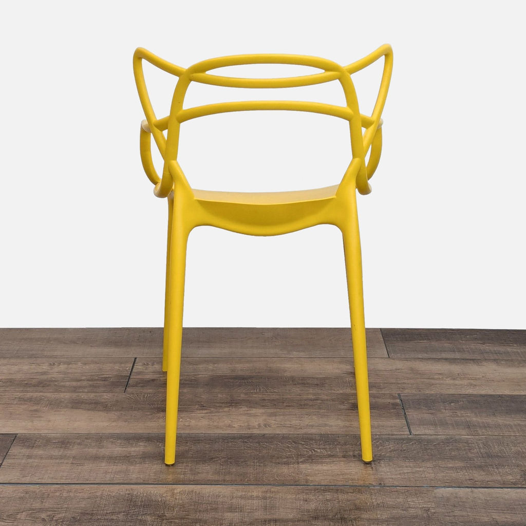3. Yellow Masters-style chair, inspired by Kartell, with a sculptural, contemporary open-back design.