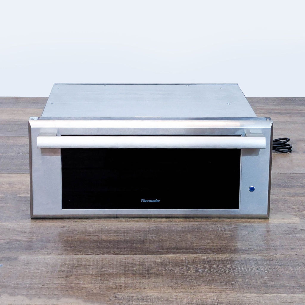 1. Front view of Thermador WD27ES warming drawer in stainless steel, ideal for keeping food warm and proofing dough.
