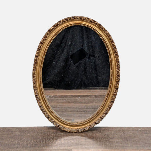 1. Oval Art Light Company mirror with ornate gold frame, displayed standing on a wooden surface.