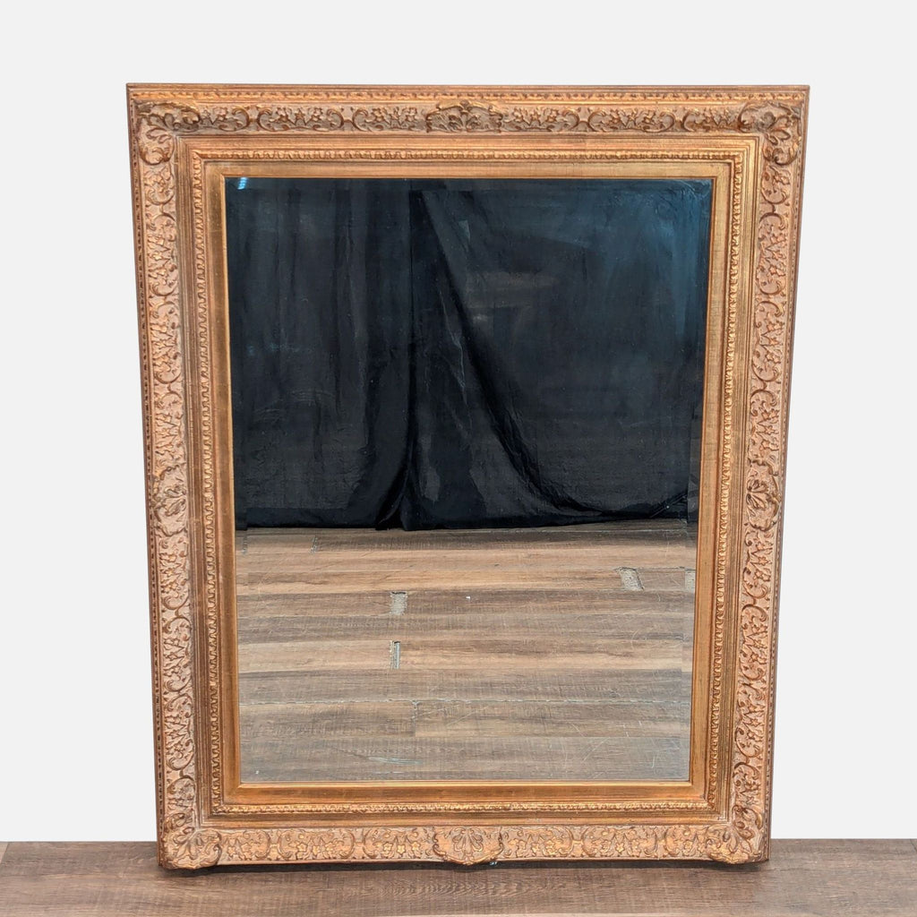 1. Ornate Tobi Designs mirror with a gold carved frame and reflective glass, shown upright on a wooden surface.