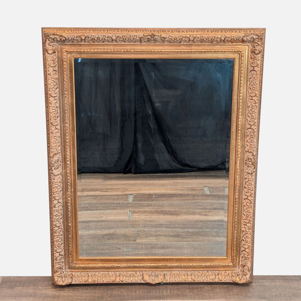 1. Ornate Tobi Designs mirror with a gold carved frame and reflective glass, shown upright on a wooden surface.