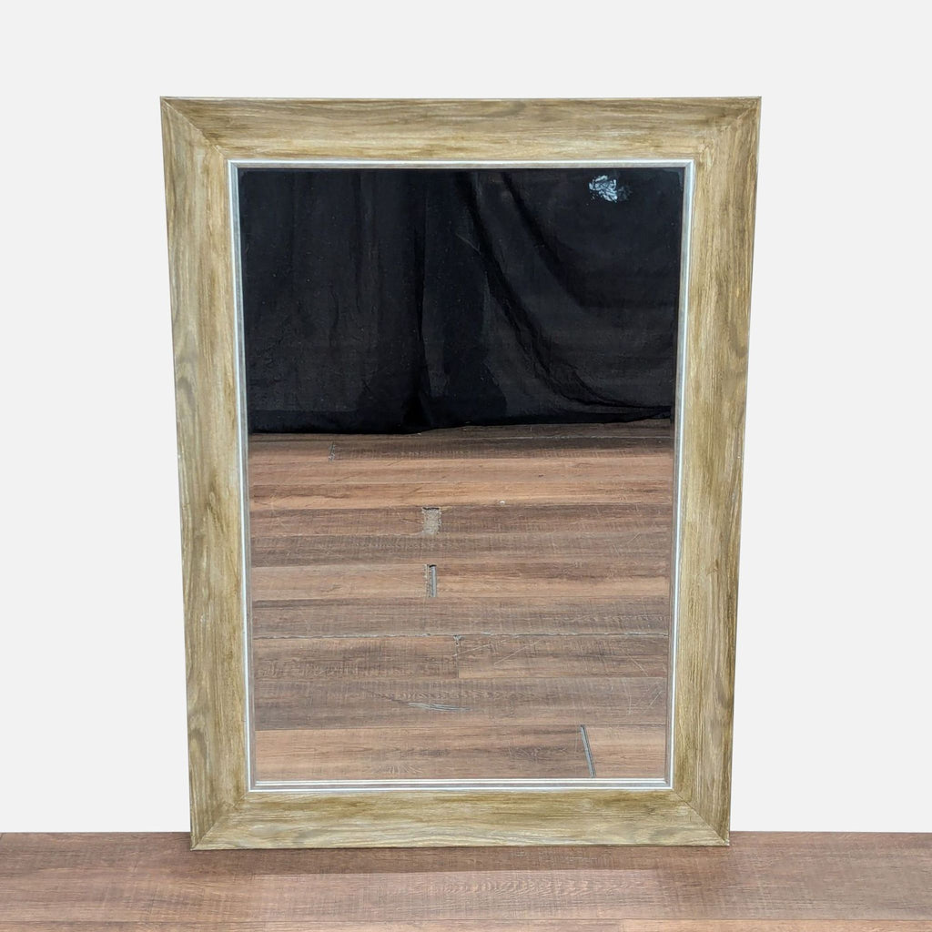 1. Rectangular Reperch mirror with a wide light wood frame, reflecting wooden flooring and a black backdrop.
