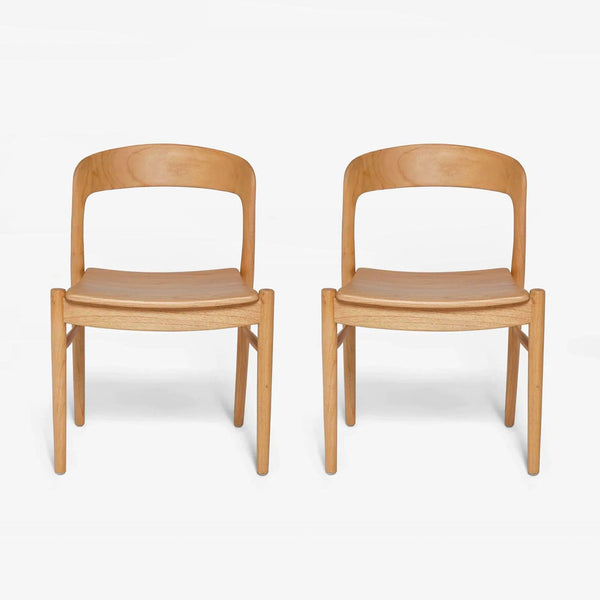 1. Pair of mid-century Lulu and Georgia dining chairs in mindi wood with curved backs and clean lines.