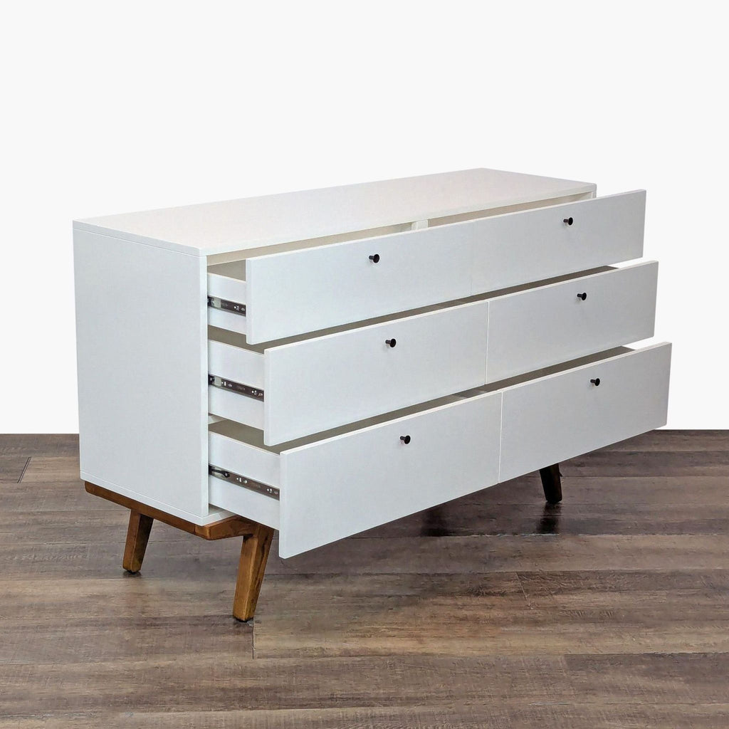 2. West Elm dresser with three open drawers, featuring gunmetal pulls and airy, angled legs on wood base.