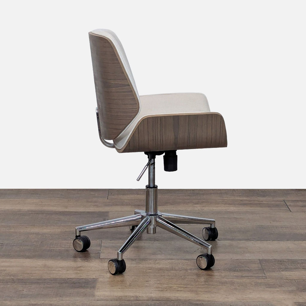 2. Side view of a Crate & Barrel chair showing bent wood seat, cream linen cushion, and adjustable chrome wheeled base.