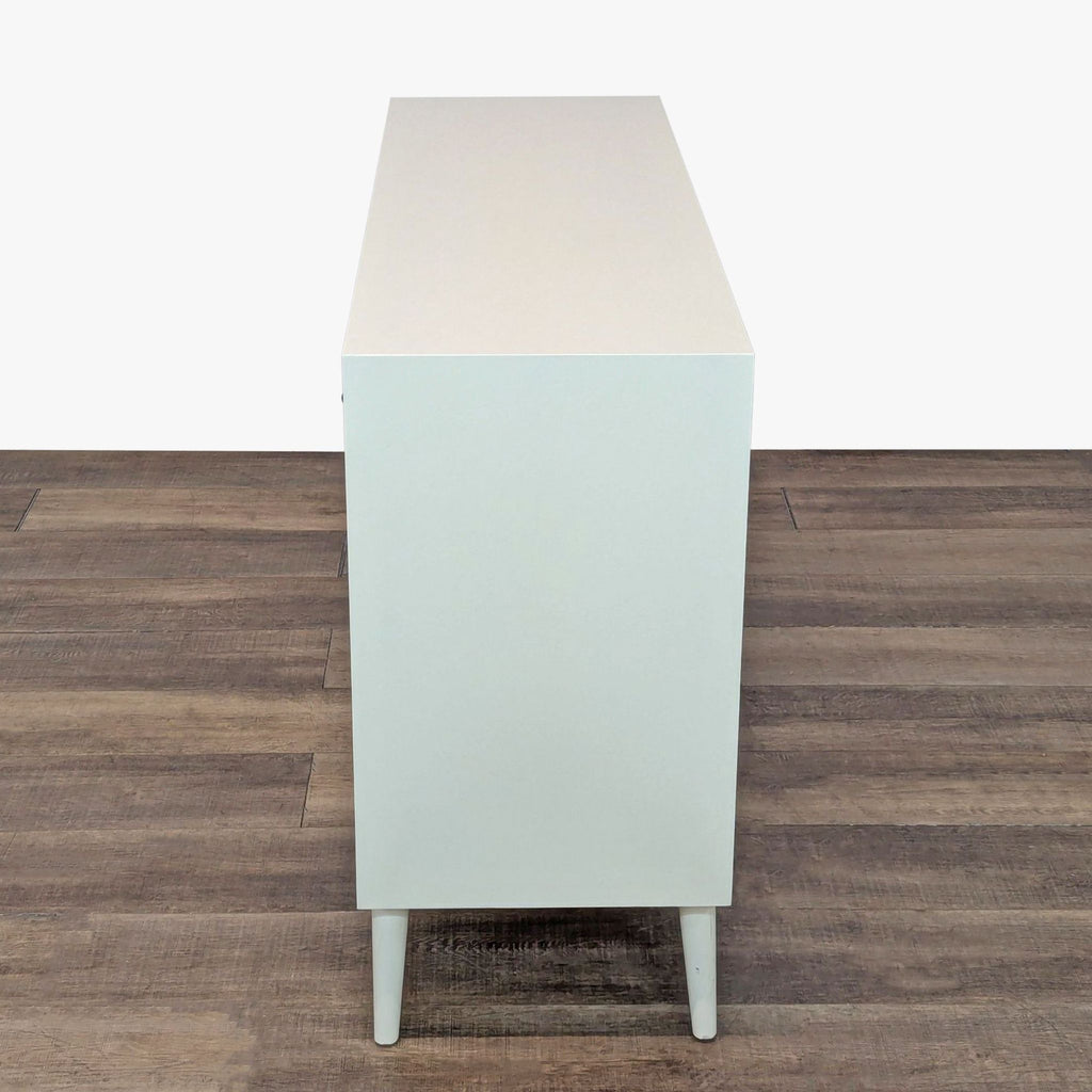 3. Minimalist white dresser from Najarian Furniture, mid-century modern style, shown in a full side profile.