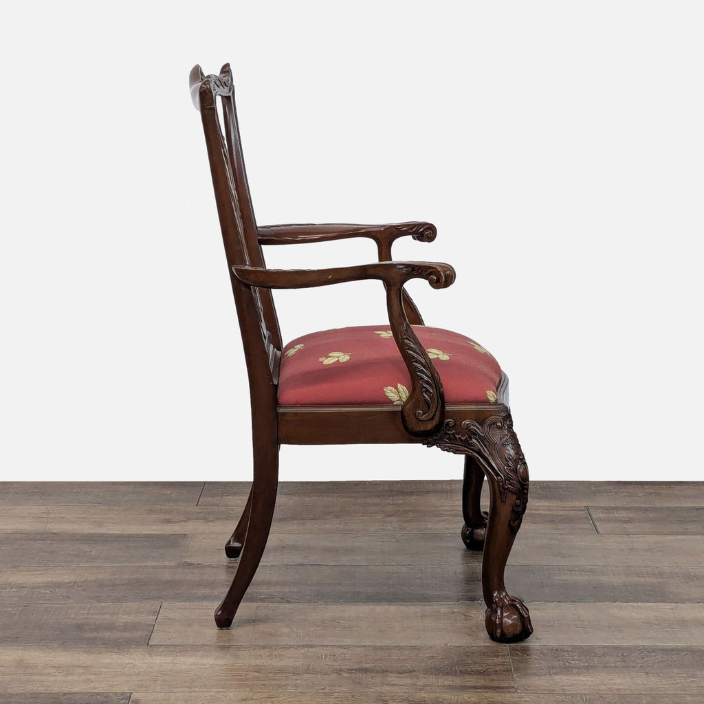 Side profile of a Chippendale style Henredon dining armchair with ornate woodwork and a red upholstered seat.