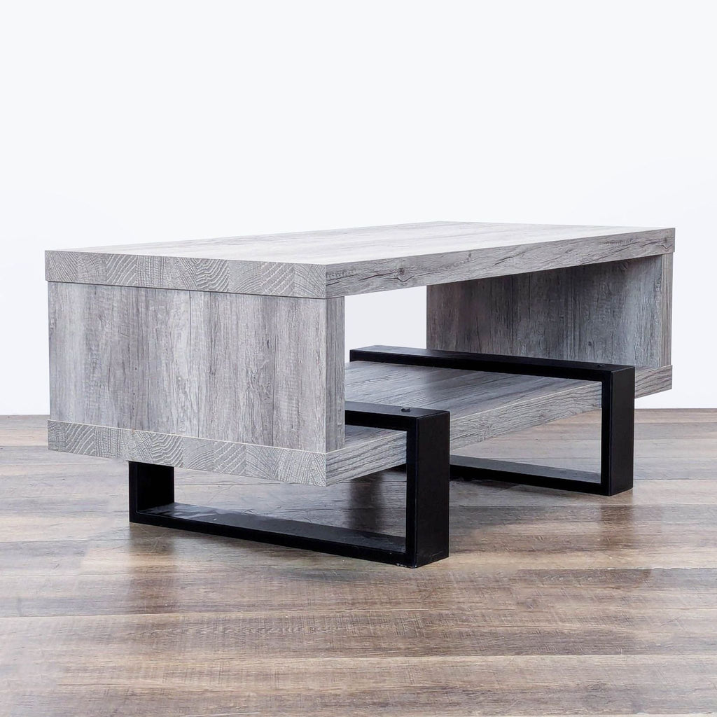 3. Rectangular Coaster coffee table with driftwood finish, open shelf, and bold black metal legs for support.
