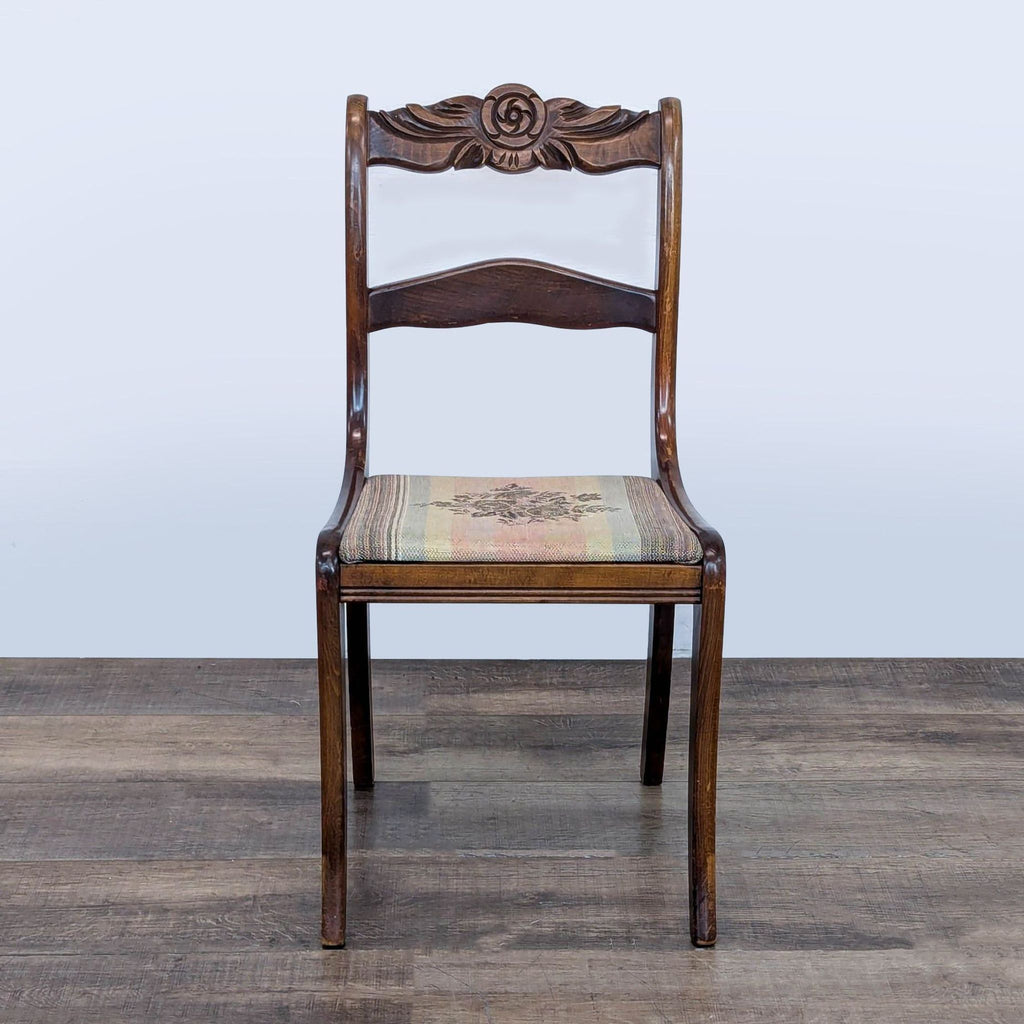 1. Reperch dining chair with ornate carved wooden backrest and floral upholstered seat, shown from the front.
