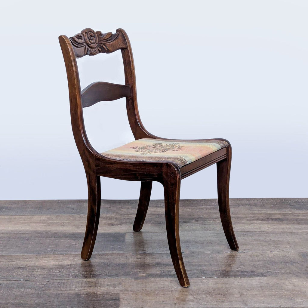 2. Side angle of a Reperch dining chair featuring curved wood frame and vintage floral fabric seat.