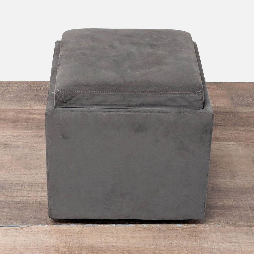 3. Contemporary square American Leather ottoman, upholstered in gray fabric with a cushioned top and sleek profile.