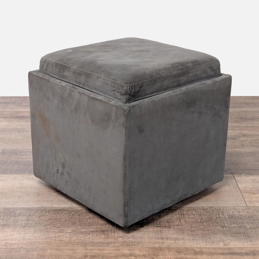 1. Square gray ottoman with plush foam seat, double-needle stitching, and smooth casters by American Leather.