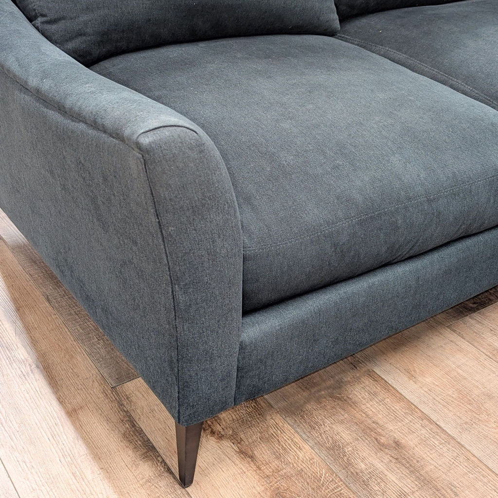 3. Detail of armrest and seat cushion from Jonathan Louis sectional, highlighting fabric texture and modern metal legs.