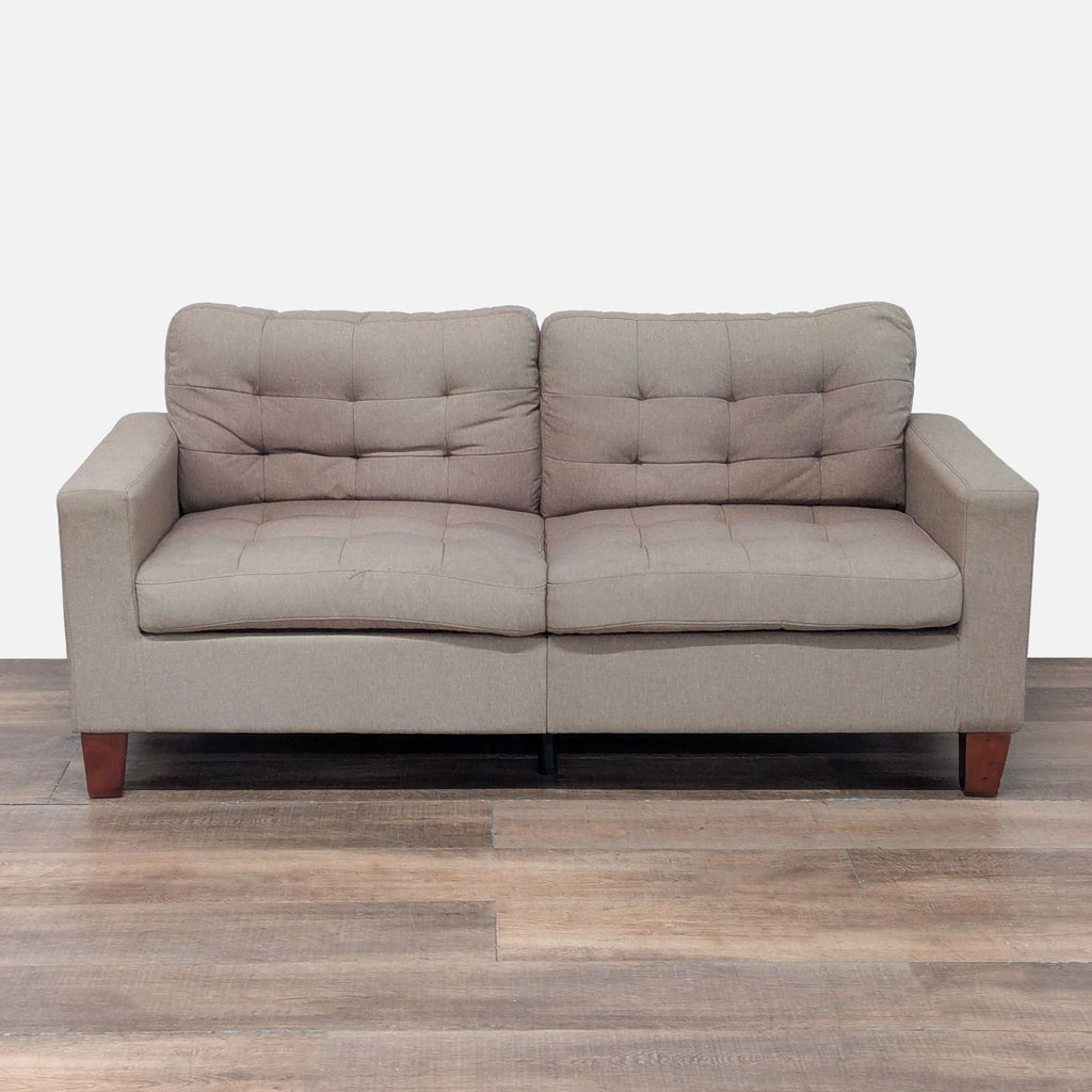 1. Front view of an Amazon loveseat with taupe tufted upholstery and tapered wood block feet.