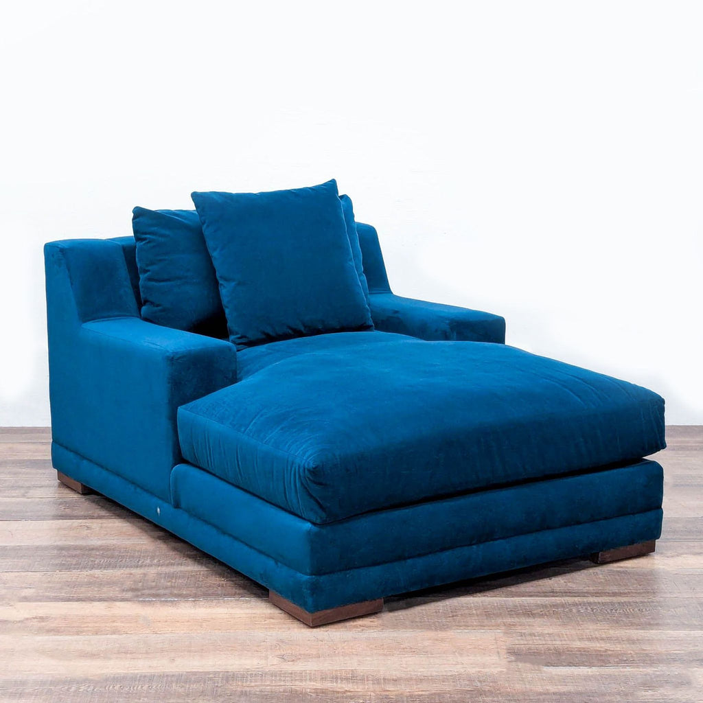 Angled view of Living Spaces chaise showing deep seating, supportive cushions, and modern track arm design.