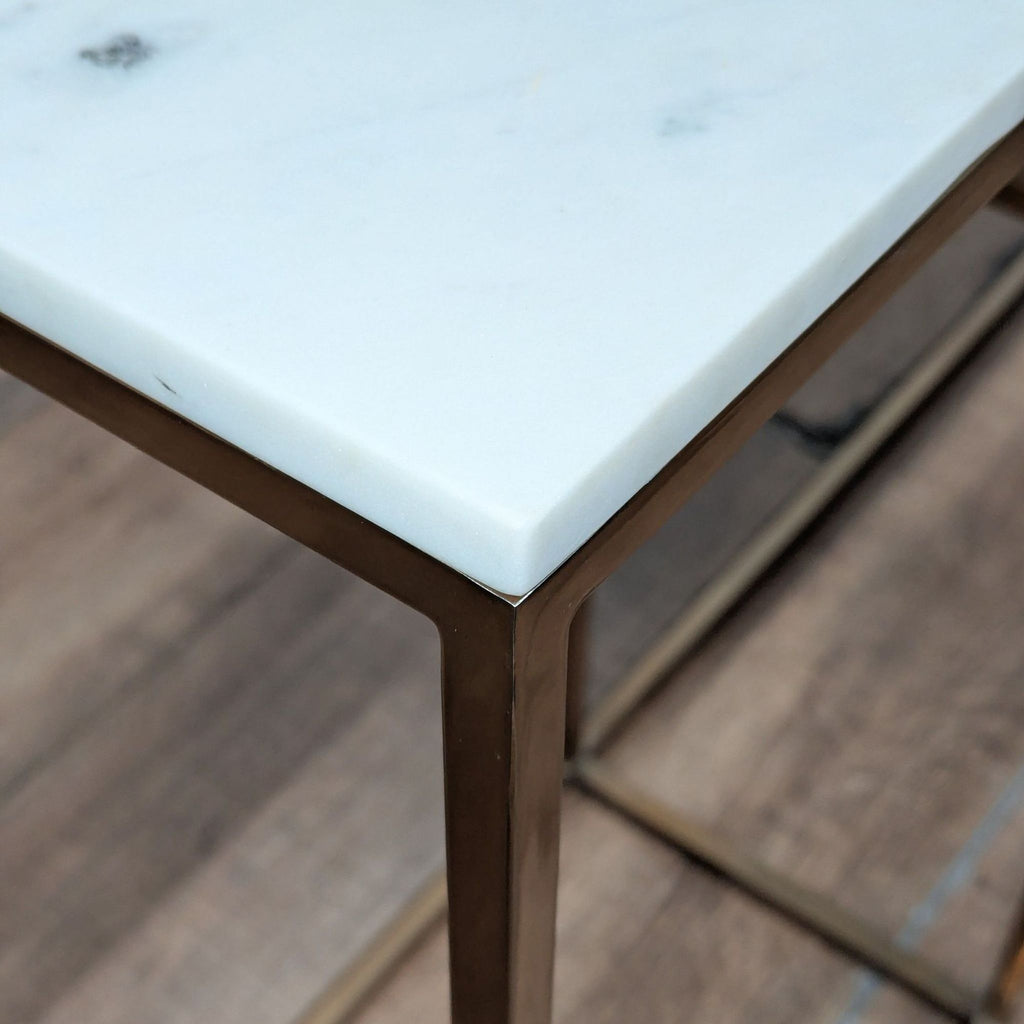3. Close-up of CB2 side table’s white marble top and metal frame, highlighting smooth edges and polished finish.