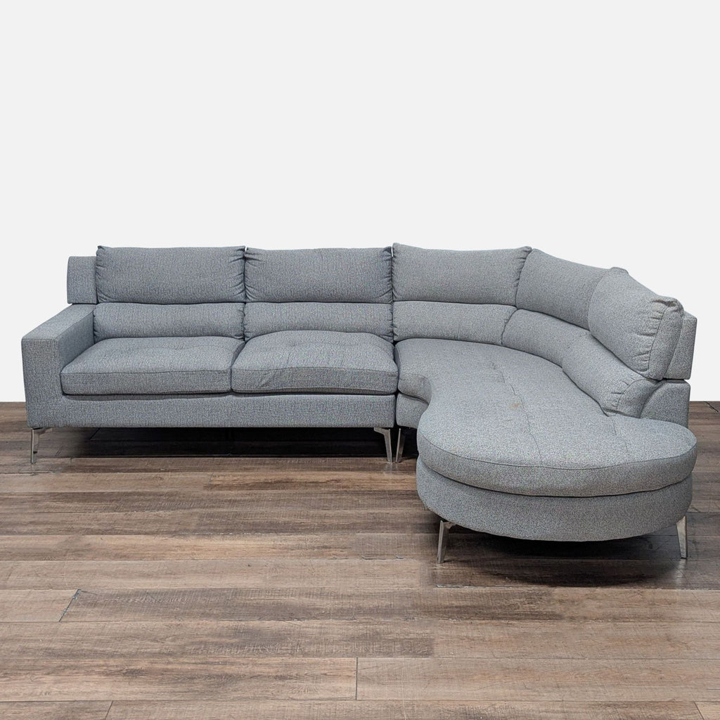 Gray Reperch sectional sofa with chrome legs, modern lines, and plush tufted back and seat cushions.
