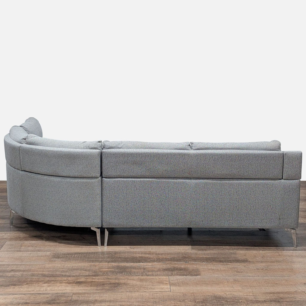 Back angle of gray Reperch sectional showing its modern profile, chrome-finished legs, and plush backs.
