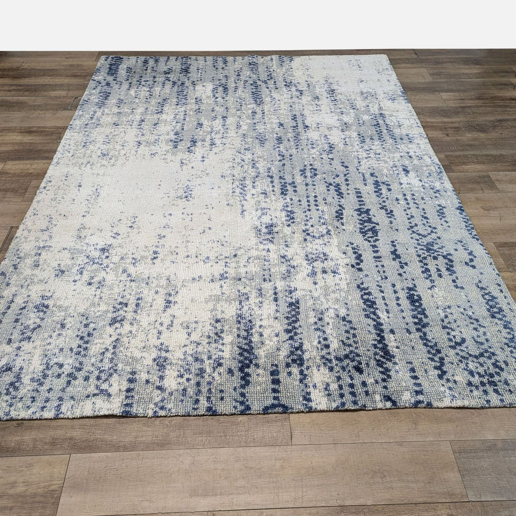 1. Hand-loomed Reperch rug with a subtly distressed look and a blue tonal vine-like cascading pattern.  