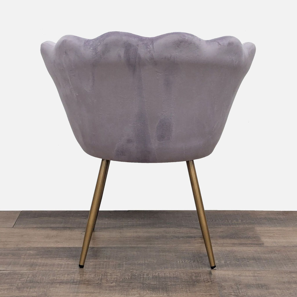 Rear view of Abble’s lounge chair featuring seashell-edged velvet upholstery and sleek gold metal legs.