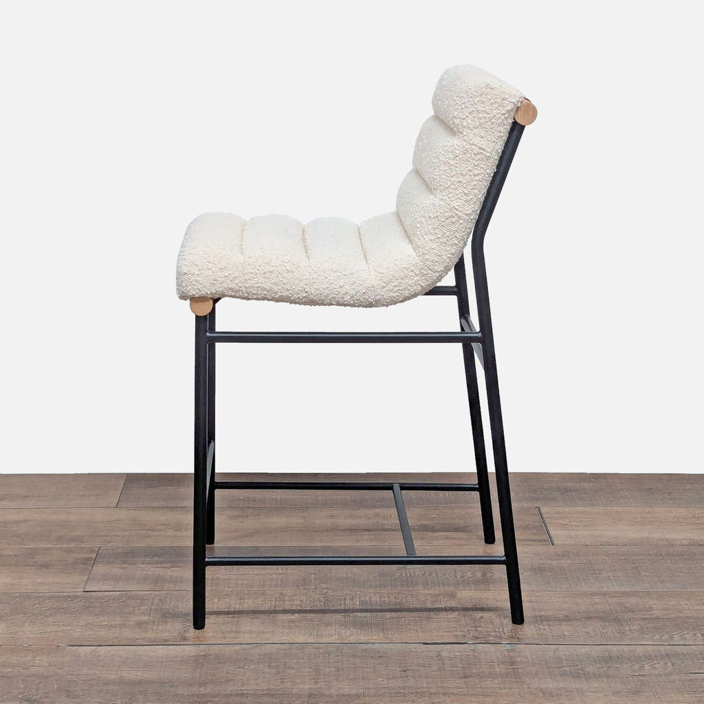 3. Side profile of Lilola Home channel tufted boucle upholstered stool with black iron base and Cognac detailing.  