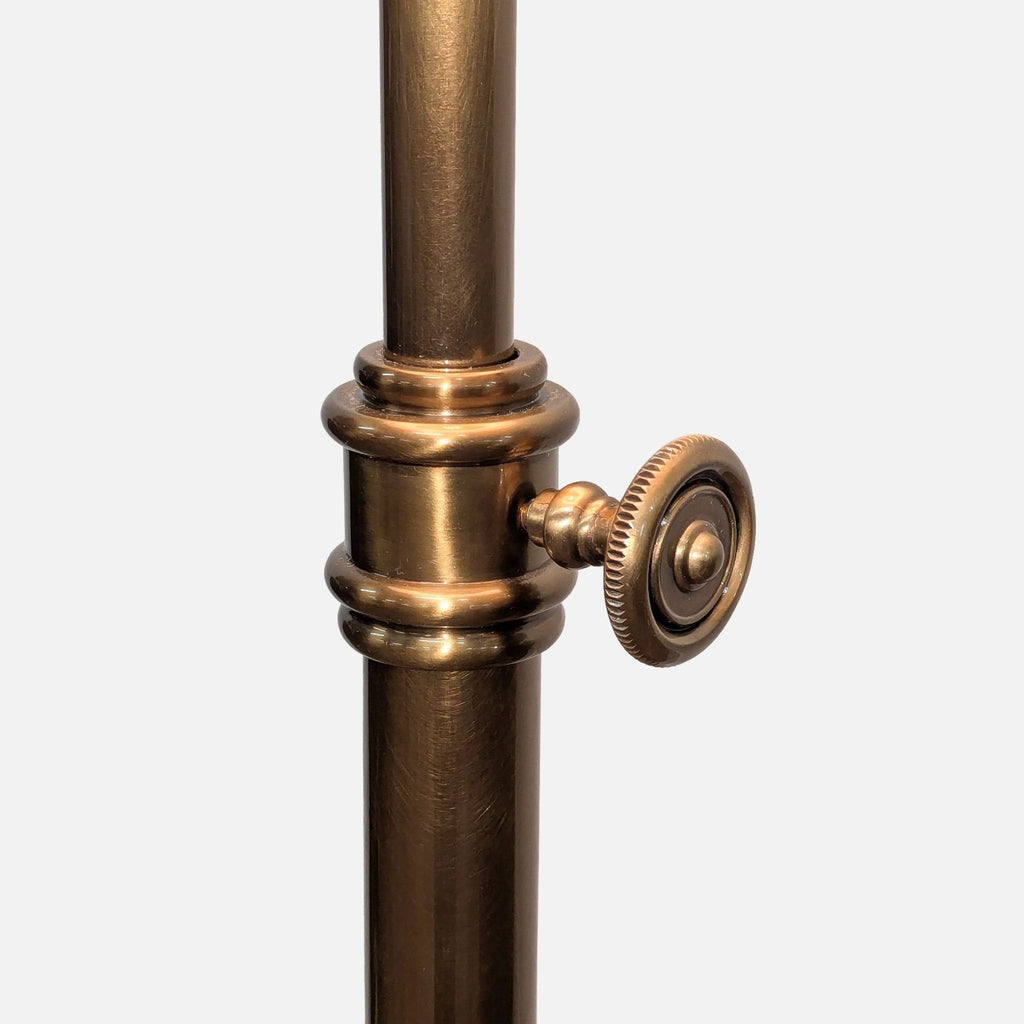 Detailed view of the adjustable knob on the gold tone metal floor lamp by Pottery Barn.