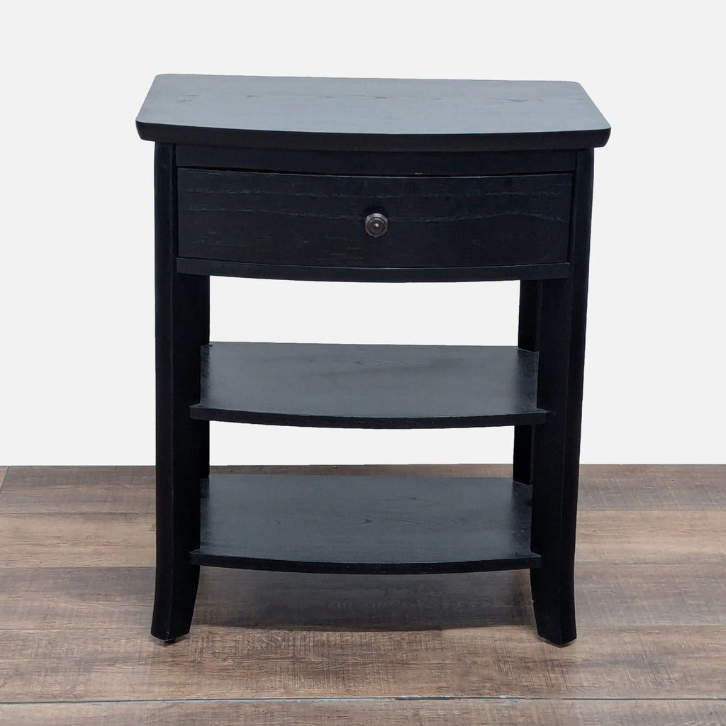 1. Black Pottery Barn end table with a single drawer and two lower shelves, set on a wood floor.