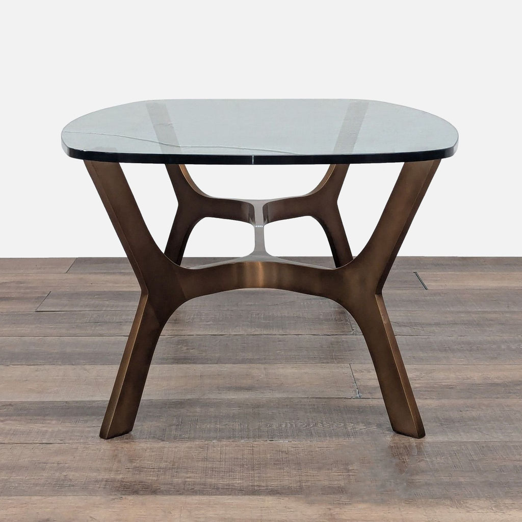 2. Side view of Crate & Barrel coffee table featuring a curved glass top and a sleek brass frame.  