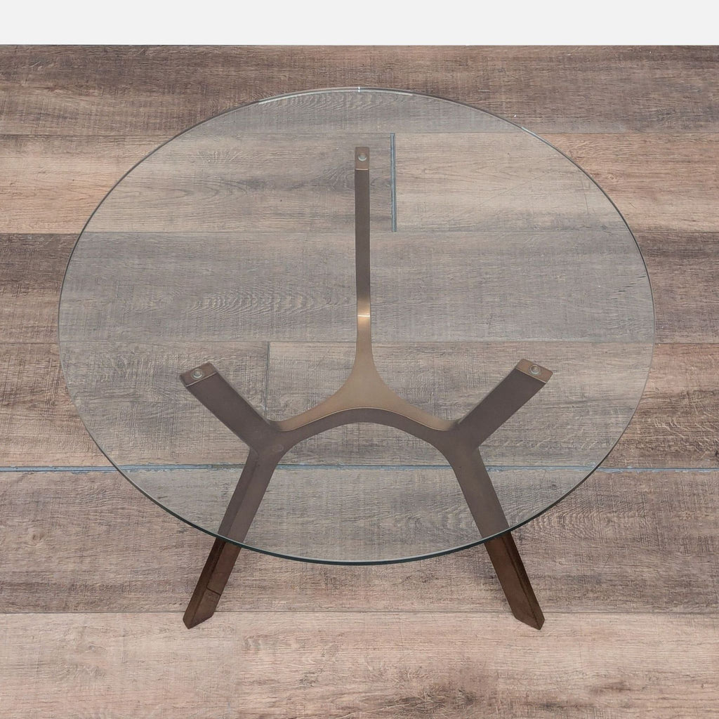 2. Top view of a Crate and Barrel end table featuring a circular glass top on a stylish brass base.