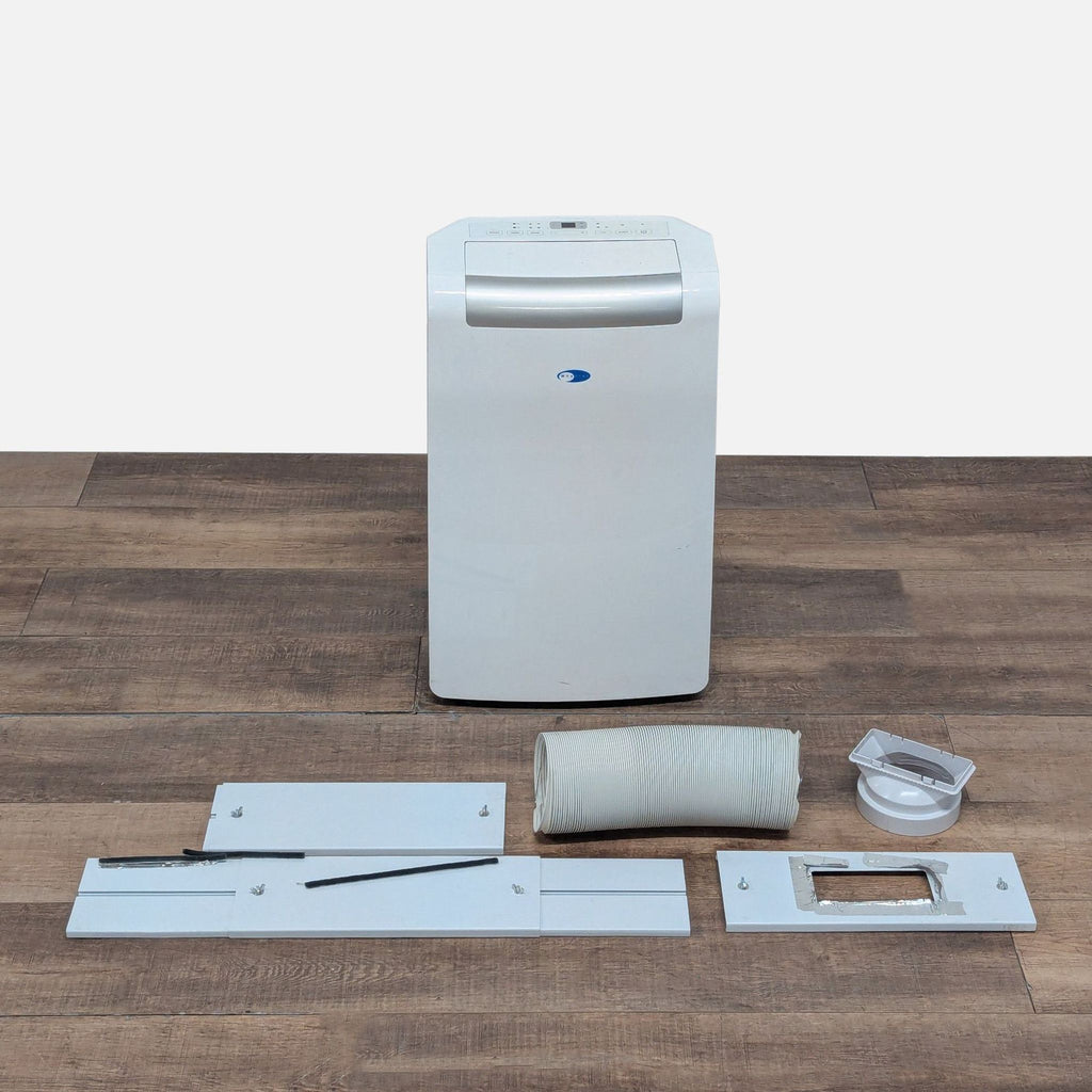 2. Whynter portable air conditioner with included hose and window installation accessories displayed on the floor.